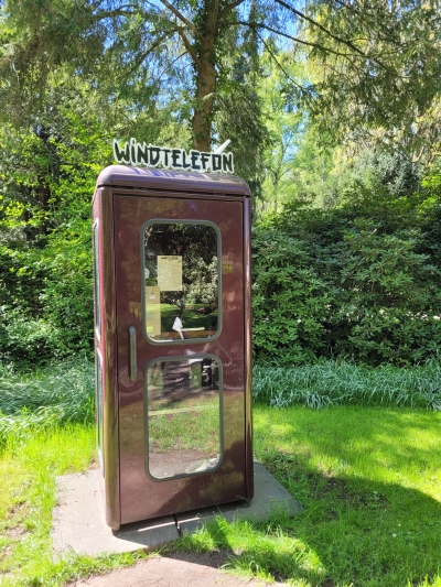 alte Telefonzelle mit Schriftzug Windtelefon auf dem Hauptfriedhof in Kassel
