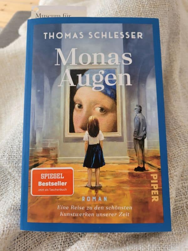 Buchcover von "Monas Augen" von Thomas Schlesser auf einer gestrickten Decke