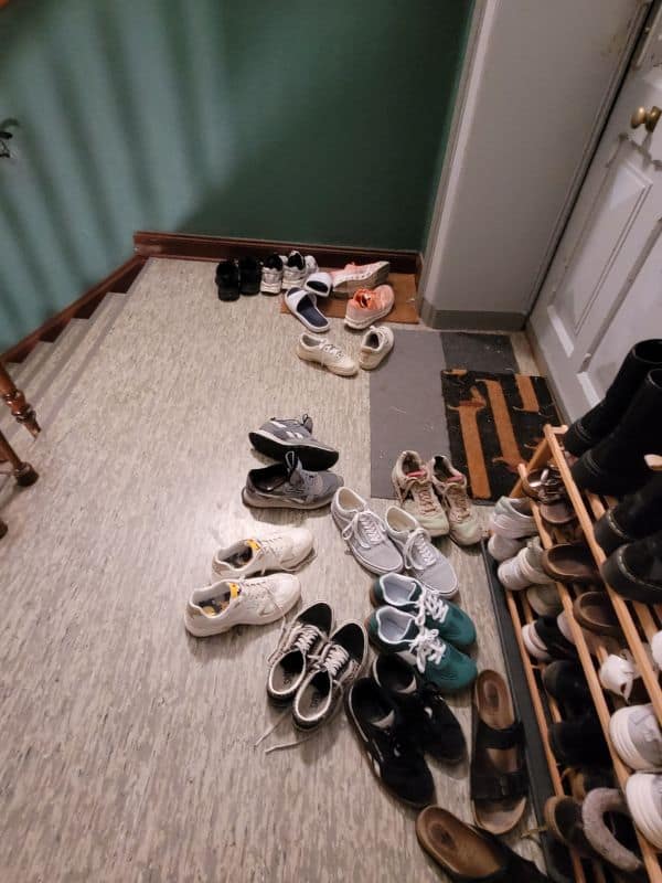 Reihen von Schuhen im Flur vor einer Treppe